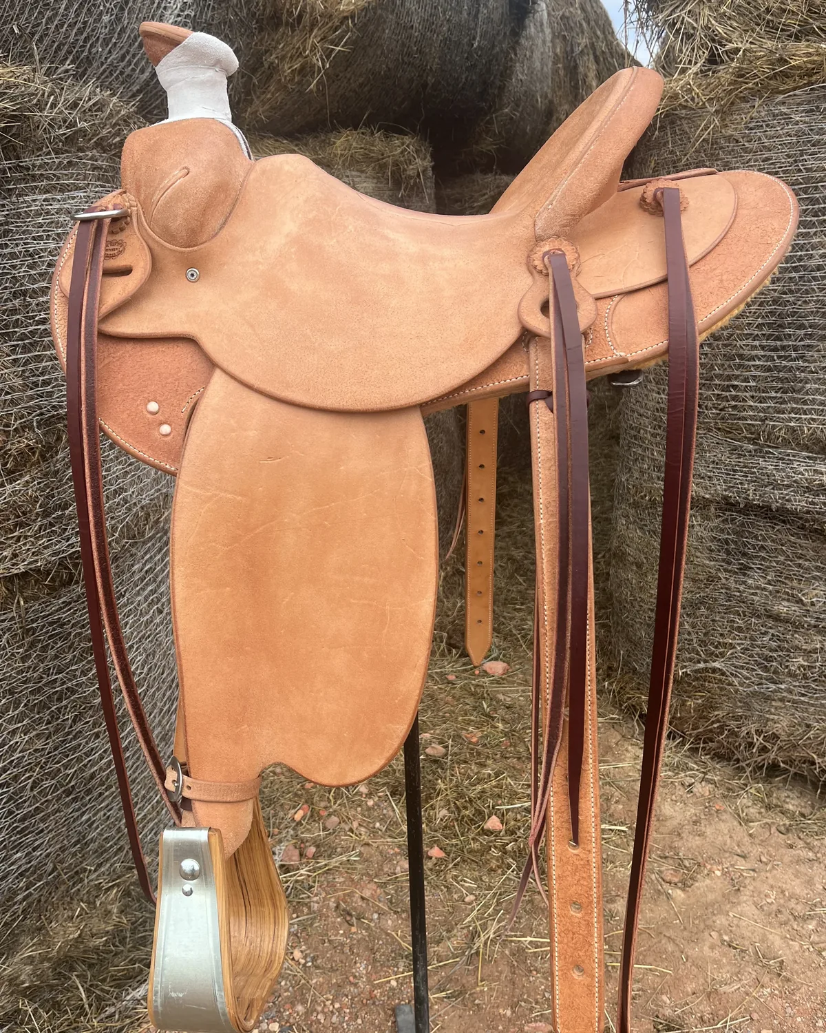 Roughout working saddle photographed against a haystack