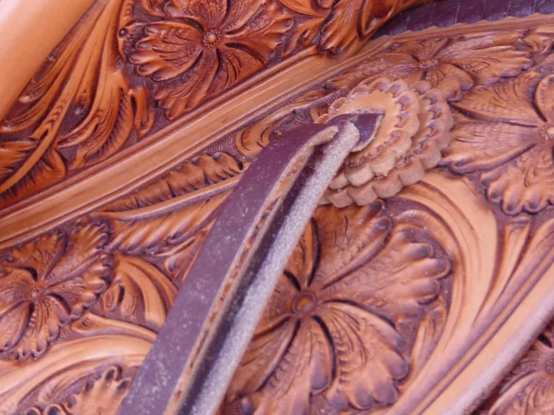 Close-up of hand-carved floral tooling on a saddle fender