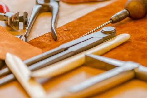 Saddler's hand tools laid out on a workbench