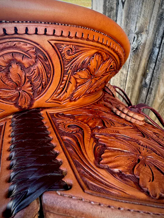 Carved floral cantle and jockeys on a finished custom saddle