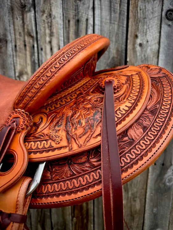 Pictorial figure carving worked into the cantle of a custom saddle