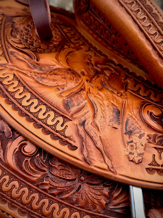 Close view of a shaded pictorial carving surrounded by hand-stamped border work