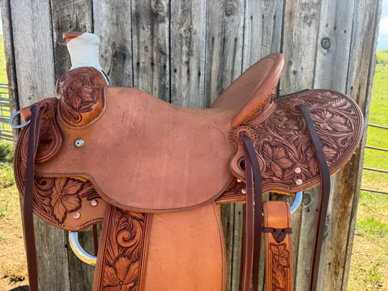 Roughout-seat ranch saddle with hand-tooled floral skirts and fenders
