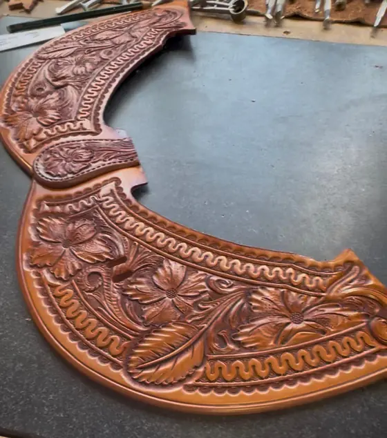Two matching carved saddle parts laid out on the bench after tooling
