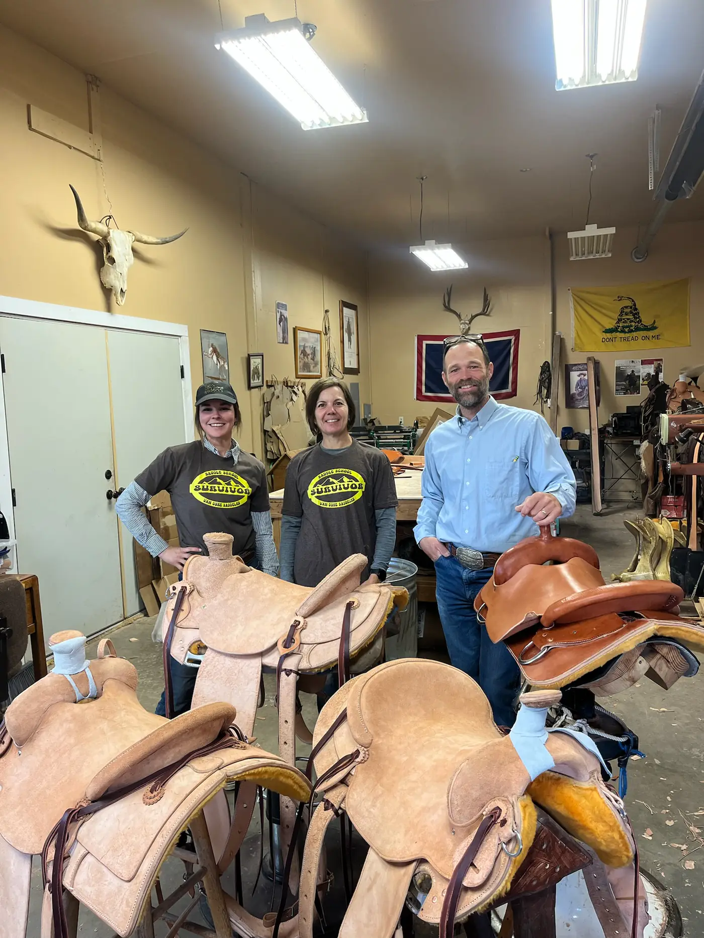 Two saddlery students in the Sheridan shop with their finished saddle trees and skirts